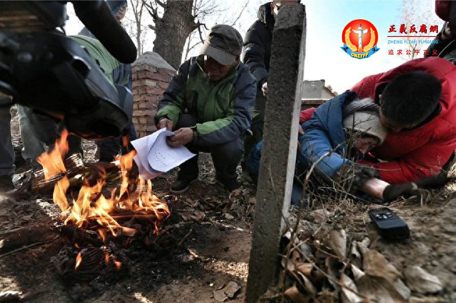 图为2014年12月15日，呼和浩特，呼格吉勒图案再审被判无罪，内蒙古自治区高级人民法院向申诉人、辩护人、检察机关送达了再审判决书。家人在其坟前烧判决书复印件。.png