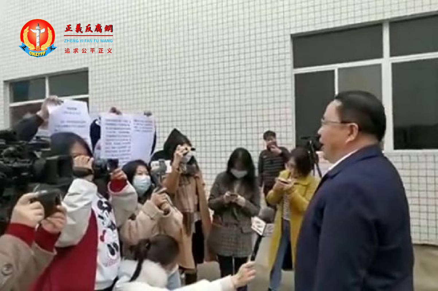 中共四川内江市发改委主任郑敏接受电视采访时，看其下属在镜头后手举的纸稿念稿的视频在网络热传。.png