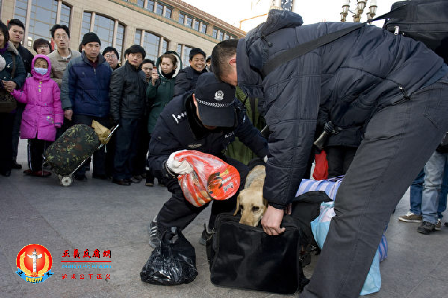图为2010年1月31日北京火车站的警察在检查旅客的行李。.png