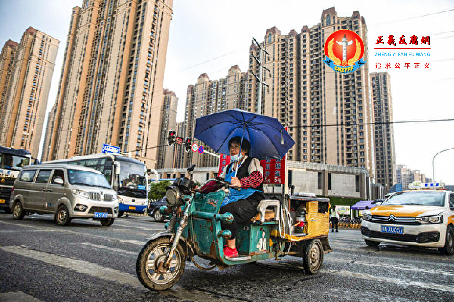 2021年9月24日，一名小贩在雨中骑车经过武汉市恒大长青社区。.png