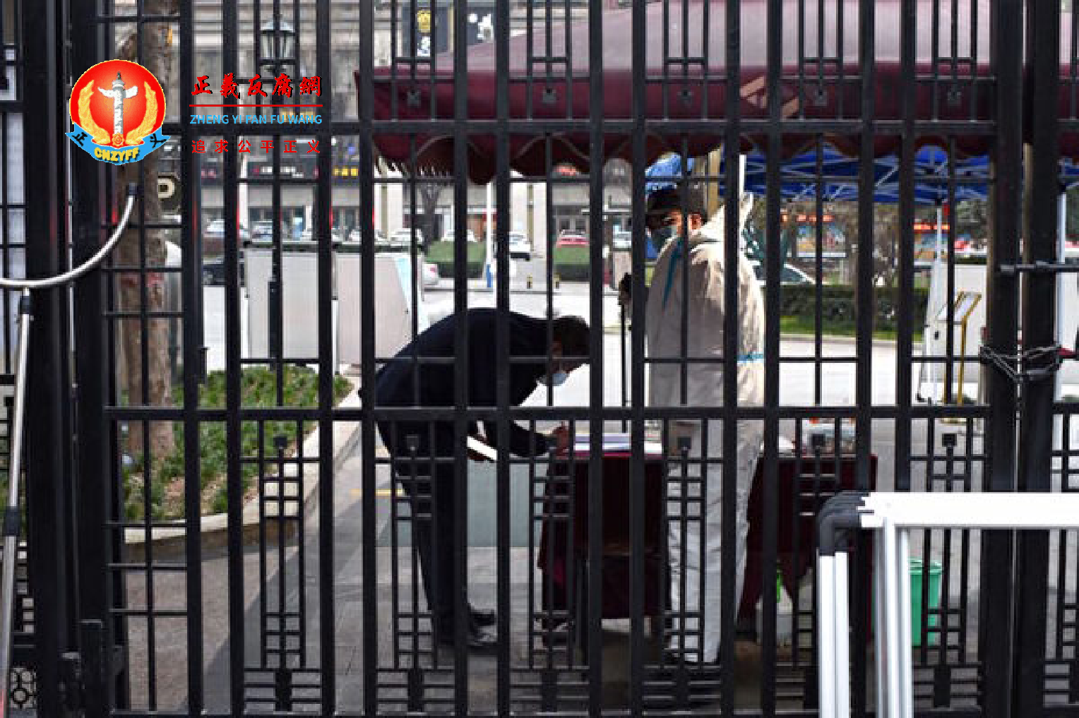 2021年12月23日，陕西西安市一名保安在居民区入口处检查居民信息。.png