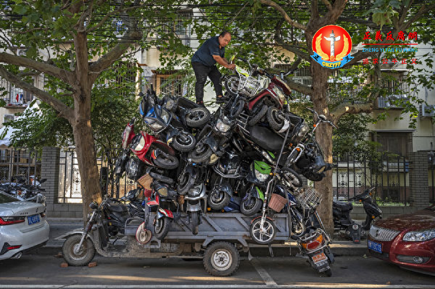 图为北京，2021年8月31日，一名工人将待回收的电动自行车堆放在他的三轮车上。.png
